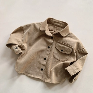 Detailed flat lay of a camel corduroy kid shirt showing soft texture and button pocket