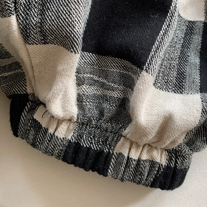 Detail der elastischen Manschette und Twill-Baumwolle an schwarz-weiß karierten Kinderhosen