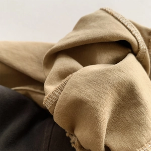 Détail du pantalon sarouel enfant kaki montrant la couture double et la texture du coton