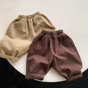 Detailed flat lay of children's khaki and brown loose cotton pants with elastic waist