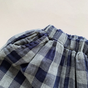 Macro shot of vintage blue checkered trousers with elastic waist and side pockets for kids