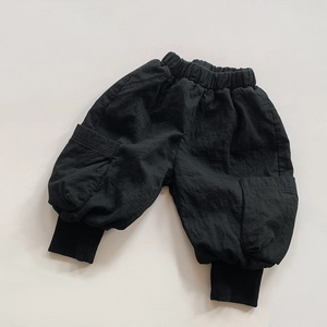Detail of children's black cargo pants showing elastic waist and large side pockets