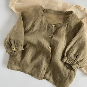Détail de la chemise en lin pour enfants avec boutons en bois et tissu respirant léger