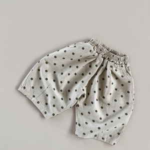Close-up of the natural linen texture and polka dot pattern on these kids loose wide-leg pants