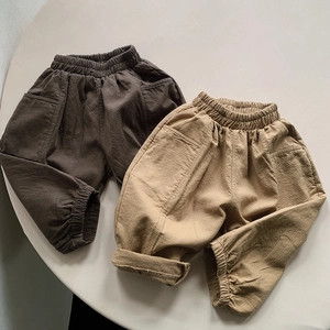 Detail view of khaki and brown cotton joggers with elastic waist and cargo pockets