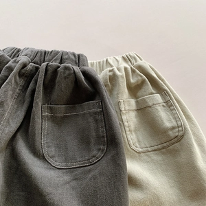 Detailed view of elastic waist and dual back pockets on kids wide-leg cotton pants