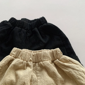 Detailed texture of black and beige cotton shorts with elastic waistband and side pockets