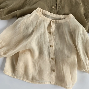 Détail de la texture des chemises de protection solaire en lin pour enfants en beige et vert