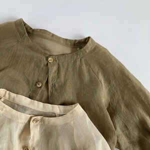 Détail de chemises de protection solaire en lin pur pour enfants avec boutons en bois