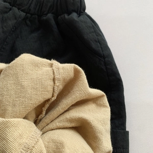Kids elastic waist cotton trousers featuring black ribbed band and khaki knit fabric texture