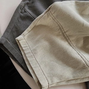 Detailed view of dark grey and light khaki cotton fabric with double stitching