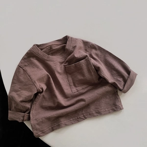 Close-up of kids slub cotton long sleeve t-shirt with chest pocket in dark brown