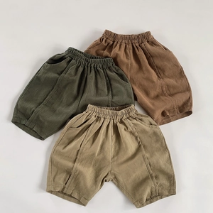 Flat lay of breathable cotton linen kids shorts in green, brown, and khaki earth tones