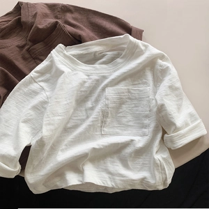 Detail view of cotton kids T-shirt with chest pocket and textured slub fabric