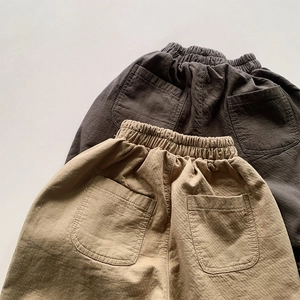 Detail of children's cotton pants showing elastic waist and dual back pockets texture