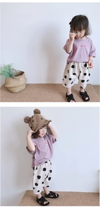 Détail du t-shirt violet en coton avec cœurs et pantalon crème à pois pour enfant