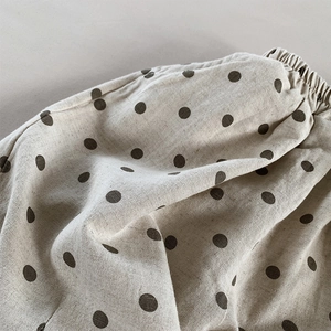 Macro view showing natural linen texture and elastic waistband of polka dot shorts