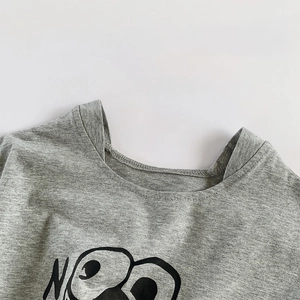 Grey cotton kids romper featuring a cute cartoon face with large eyes and round neckline