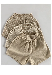 Detailed flat lay of three pairs of cotton-linen blend baby shorts in neutral earth tones