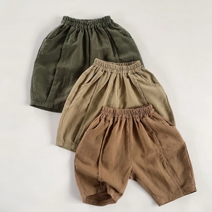 Detailed flat lay of three linen cotton shorts in green, khaki, and brown for children
