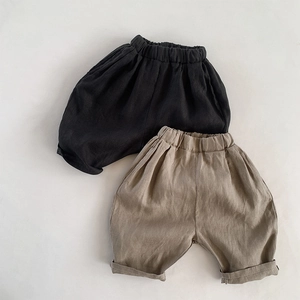 Flat lay of black and khaki linen cotton loose shorts for kids with rolled cuffs