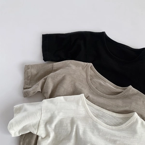 Gros plan de trois t-shirts en coton flammé noir, avoine et beige montrant la texture