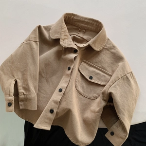 Detailed close-up of khaki cotton kids shirt featuring classic collar and black buttons