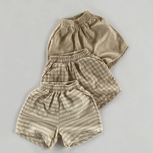 Détail de trois shorts respirants en coton et lin pour enfants avec taille élastique