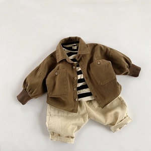 Detailed flat lay of children's corduroy jacket, striped shirt, and beige trousers set