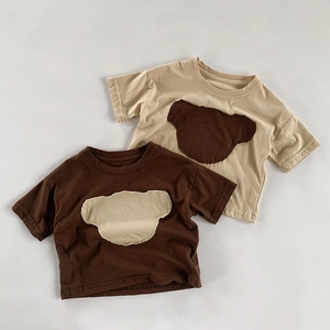 Détail de t-shirts pour enfants beige et marron avec des écussons ours minimalistes