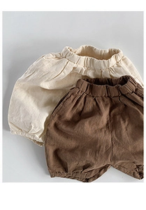 Close-up of breathable cotton linen kids shorts with elastic waist in cream and brown
