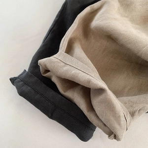 Macro detail of breathable linen fabric texture and rolled cuffs on summer kids shorts