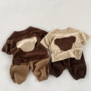 Détail d'ensembles bébé en coton avec broderie ours et texture de tissu gaufré respirant