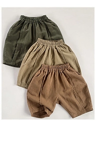 Vista piatta di pantaloncini estivi in cotone traspirante per bambini in verde e cachi
