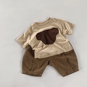Détail de l'ensemble t-shirt en coton beige avec broderie ours et short pour enfant