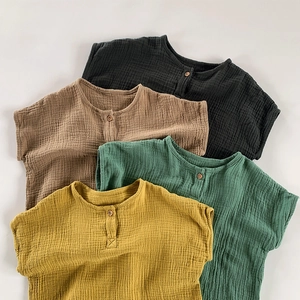 Detail showing various colors of soft double gauze cotton baby rompers with wood buttons