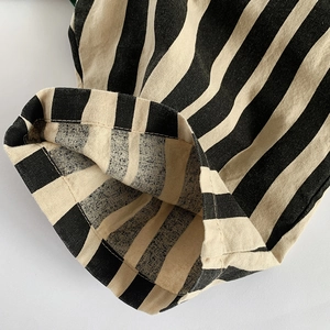 Dettaglio del tessuto in cotone a righe verticali nero e beige con trama naturale