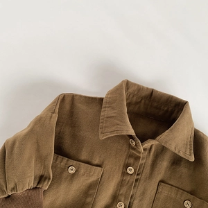 Close-up of brown corduroy kids shirt with wood-grain buttons and ribbed cuffs