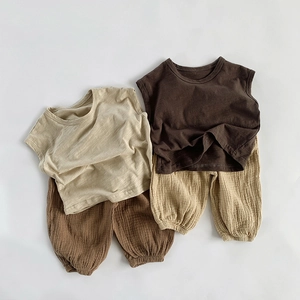 Detailed flat lay of breathable slub cotton children vests and pants in earth tones