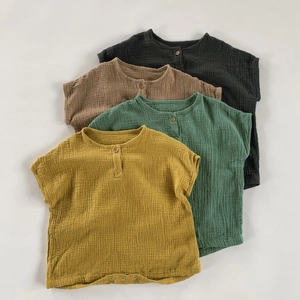 Detail of four breathable double gauze cotton baby rompers in soft earth tone colors