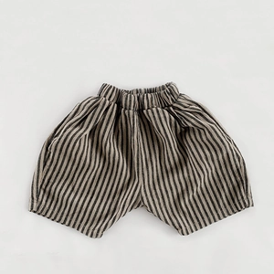 Detailed view of elastic waistband and pockets on children striped cotton linen shorts