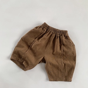 Detail of brown linen cotton shorts for kids showing elastic waist and textured fabric
