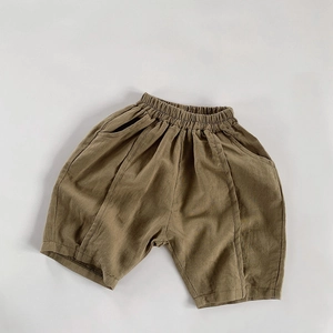 Detailed texture of olive green cotton linen kids shorts with elastic waist and stitching