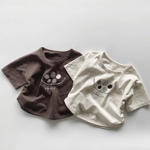Detaillierte Nahaufnahme der weichen Baumwolltextur auf braunen und beigen Kinder-T-Shirts