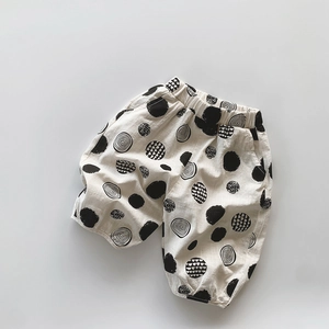 Texture détaillée du pantalon en coton flammé blanc cassé avec pois noirs abstraits