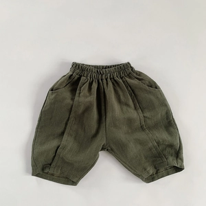 Detailed texture of army green cotton linen kids shorts with elastic waist and pockets