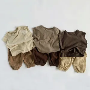 Flachbild von drei Baby-Sets aus Baumwollmull mit Weste und Pumphose in Beigetönen