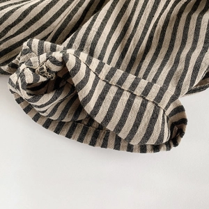 Black and yellow vertical striped cotton linen shorts showing leg cuff texture