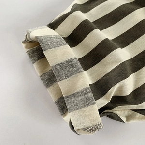 Close-up of minimalist striped cotton pants with detailed stitching and woven texture