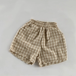 Gros plan d'un short enfant en lin et coton respirant avec motif vichy marron et taille élastique